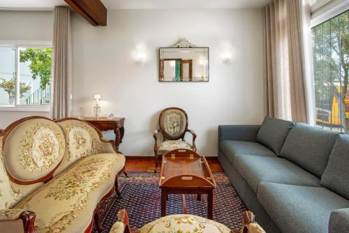 a living room with a couch and a table at Casa Caminho do Palheiro - Funchal in Funchal