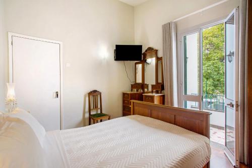 a bedroom with a bed and a window at Casa Caminho do Palheiro - Funchal in Funchal