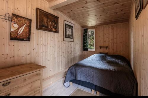 ein Schlafzimmer mit einem Bett in einer Holzhütte in der Unterkunft Geilo Living in Holo