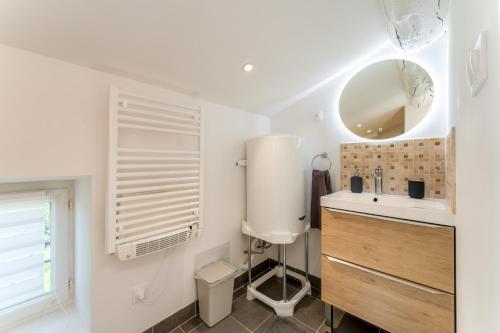 a bathroom with a sink and a toilet and a mirror at Gite en Campagne Valentin in Avignon