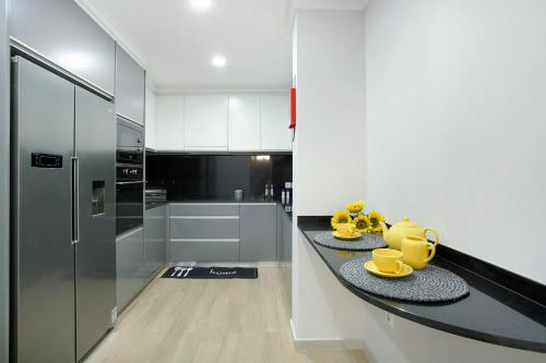 a kitchen with a counter with yellow mugs on it at Alegria Dream Home in Funchal