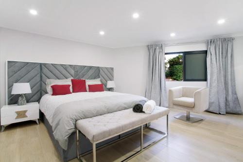a white bedroom with a large bed and a chair at Alegria Dream Home in Funchal