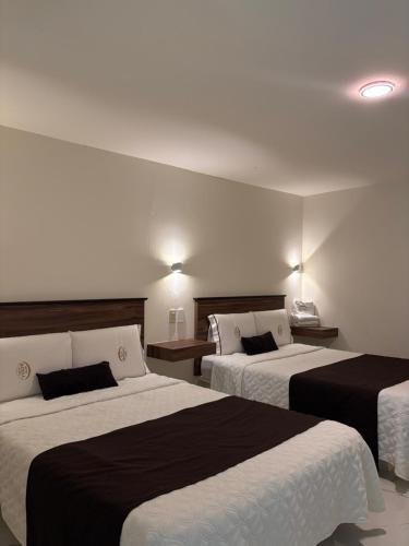 a hotel room with two beds with black and white sheets at Hotel Royal Puebla in Puebla