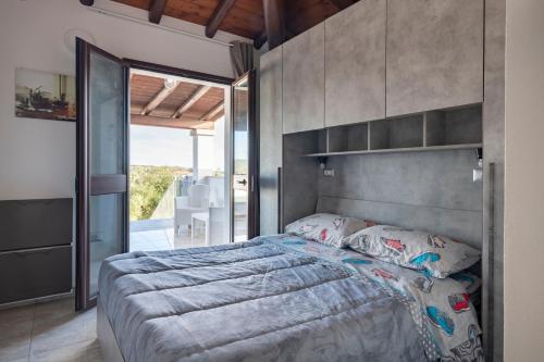 a bedroom with a large bed and a large window at Pasquale Home Holiday in Bari Sardo