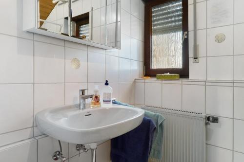 a white bathroom with a sink and a mirror at Ferienwohnung Schöne Aussicht in Gemmrigheim
