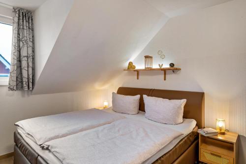 a bedroom with a bed with two lights on it at Domizil Eden - Obergeschoss in Göhren-Lebbin