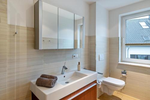 a bathroom with a white sink and a toilet at Domizil Eden - Obergeschoss in Göhren-Lebbin