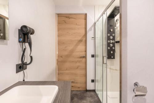 a bathroom with a tub and a phone next to a door at Villa Lara Zirbe in Castelrotto