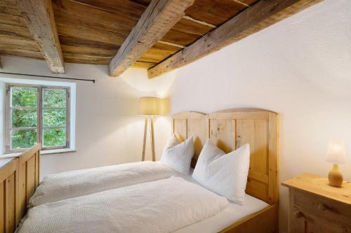 a bedroom with a white bed with a wooden headboard at Ansitz Baumannhof Apt Mitte in Falzes