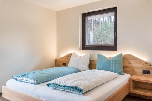 a bed with two pillows on it in a room at Villa Lara Zirbe in Castelrotto