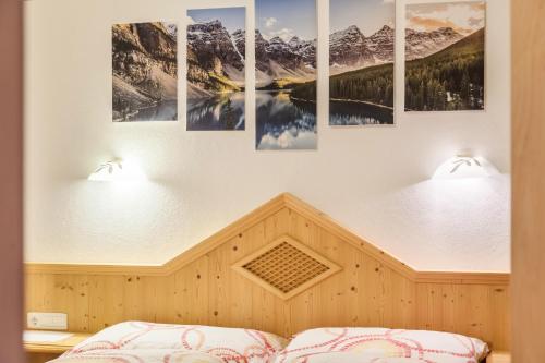 a bedroom with snow capped mountains on the wall at Apart Joachim in Fügen
