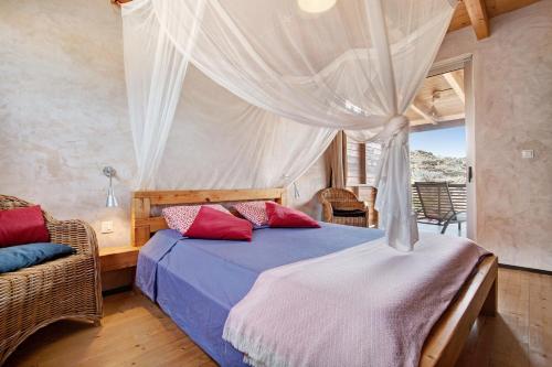 a bedroom with a bed with red pillows at Tayu Eco Villa in Villaverde