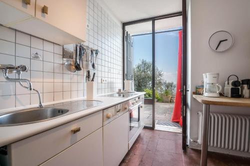 a kitchen with a sink and a large window at Villa Bianca in Toscolano Maderno