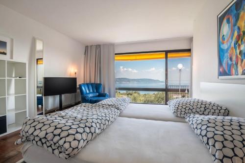 a hotel room with a bed and a large window at Villa Bianca in Toscolano Maderno
