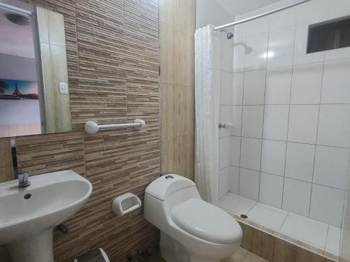a bathroom with a toilet and a sink and a shower at Hospedaje costa pacífico in Chimbote