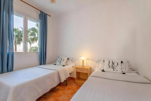 two beds in a room with a window at Appartement avec 2 piscines in Mutxamel