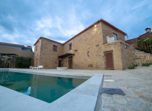 a house with a swimming pool in front of a building at Villae Carreiro in Palmeira