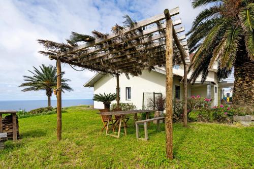 a picnic table in front of a house at Casinha do Monte in Achadinha