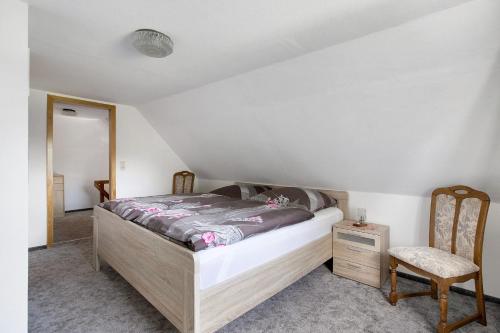 a bedroom with a bed and a chair at An der Rehkoppel in Boren