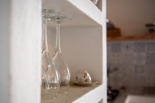 two wine glasses sitting on a shelf in a kitchen at Gea - In Parulia Country House in Arezzo