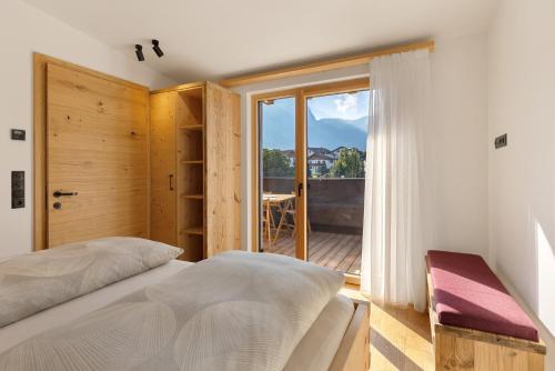 a bedroom with a bed and a large window at Apartments Schlernheim in Fie allo Sciliar