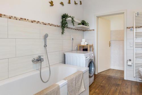 a bathroom with a tub and a washing machine at Ferienhaus Optikstadt Rathenow in Rathenow