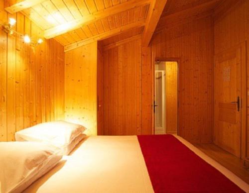 a bedroom with a bed with a red blanket on it at Chalet Myrtille in Morzine
