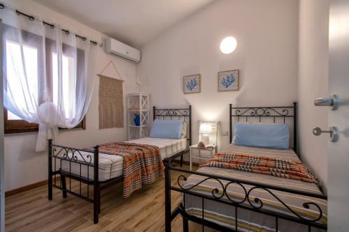 a bedroom with two beds and a window at Villa Aloe in Costa Paradiso