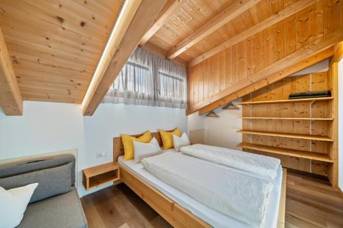 a bedroom with a bed in a room with wooden ceilings at Matscherhof Ferienwohnung Helena in Santa Valpurga
