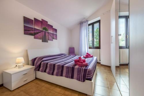 a bedroom with a bed with pink shoes on it at Alle Rive apartment in Salò