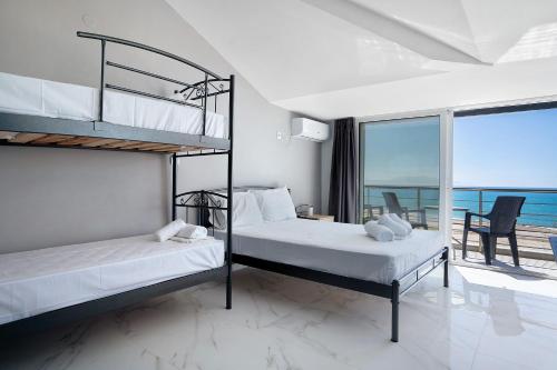 two bunk beds in a room with a view of the ocean at Iguana studio 18 in Preveza