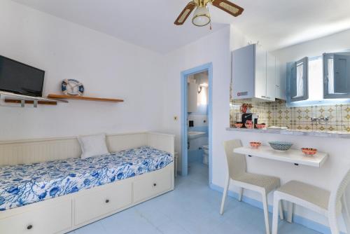 a bedroom with a bed and a table and chairs at Villa Oda - Bilocale sul mare in Capoliveri
