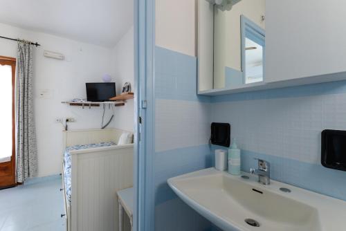 a bathroom with a sink and a mirror at Villa Oda - Bilocale sul mare in Capoliveri