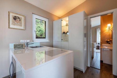 a white bathroom with a sink and a mirror at Ferienwohnung Casa 50 in Gargnano
