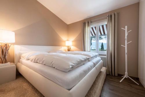 a large white bed in a room with a window at Ferienwohnung Casa 50 in Gargnano