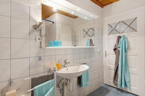 a white bathroom with a sink and a shower at La Fleur in Tengen