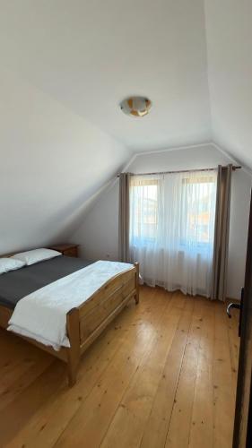 a bedroom with a bed and a wooden floor at Figa Retreat in Beclean