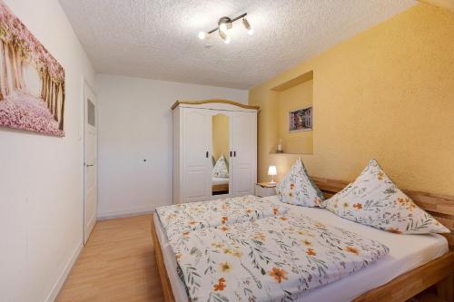 a bedroom with a bed with a floral bedspread at La Fleur in Tengen