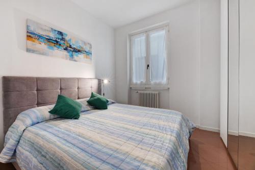 a bedroom with a bed with two green pillows at Domaso front lake in Domaso