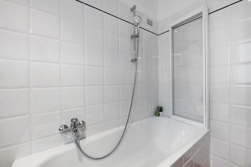 a shower in a white tiled bathroom with a tub at Domaso front lake in Domaso