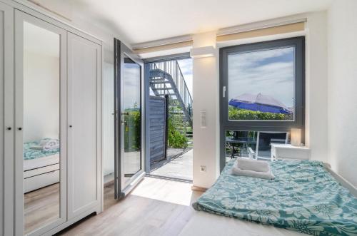 a bedroom with a bed and a large window at Blauer Seestern in Allensbach