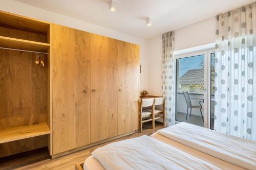 a bedroom with a bed and a window and a desk at Haus Rosengarten Apt B in Terlano