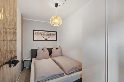 a small bedroom with a bed and a pendant light at Sonnenterrasse im Schwarzwald in Freudenstadt