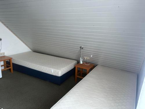 two twin beds in a room with two tables at Sternschnuppe in Kirchheim