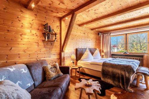 a log cabin bedroom with a bed and a couch at Chalet Alpenherz in Inzell