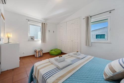 a bedroom with a bed with two towels on it at V-Blue in Alvor