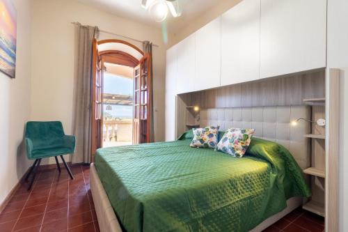 a bedroom with a green bed and a green chair at Villa Serra in Marina Serra