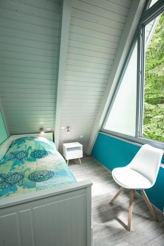 a bedroom with a bed and a chair at Ferienhaus Waldperle in Ronshausen