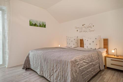 a bedroom with a bed in a white room at Familien-Apartment 2 in Meersburg