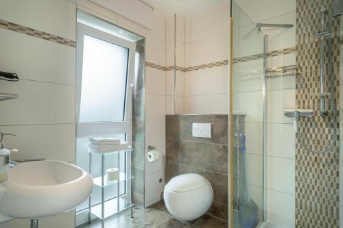 a bathroom with a sink and a toilet and a shower at Familien-Apartment 2 in Meersburg